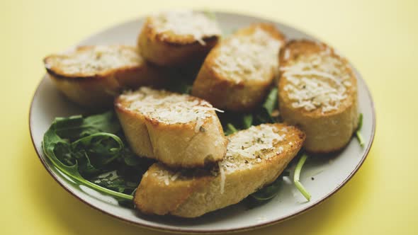 Slices of Garlic Cheese Bread Served on a Plate Arugula Leaves
