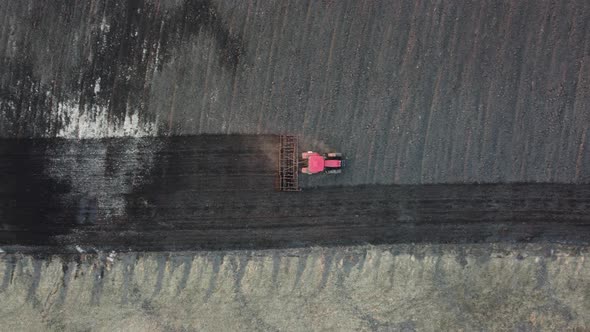 Shooting From Drone Flying Over Tractor Plowing Field Early Spring Top View alt