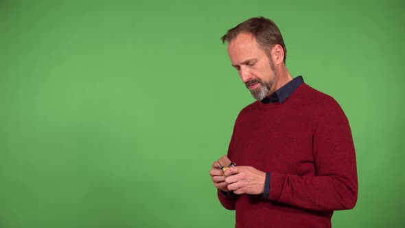 A Middleaged Handsome Caucasian Man Eats a Chocolate Bar  Green Screen Background