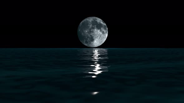 Low, big moon over the waves of the sea at night