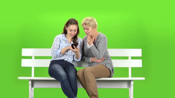 Girl Shows Something in the Phone To Her Mother. Green Screen alt