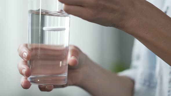 Woman Holding Glass of Water, Putting Tablet of Aspirin Into It, Painkiller alt