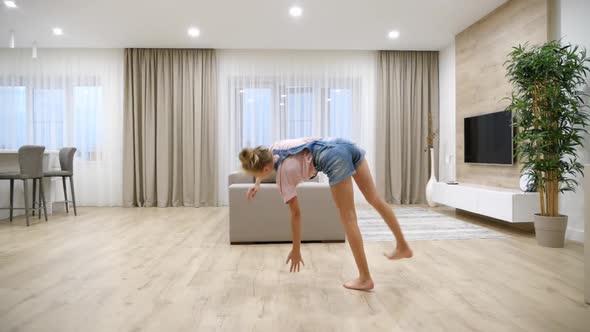Preteen Girl Standing Upside Down on Her Arms in Living Room