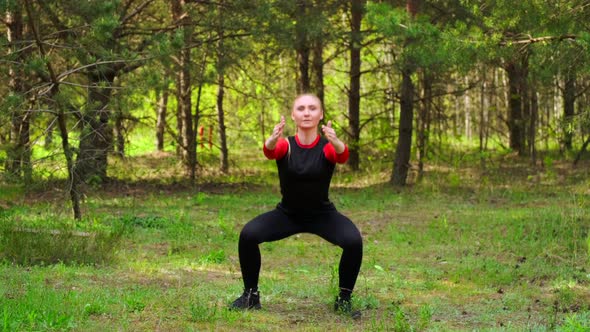 Front View Of Sportive Girl Doing Squats In Park