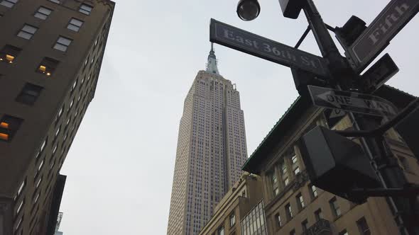Low Angle Pan Shot Midtown Manhattan Street Signs and the Empire State Building alt