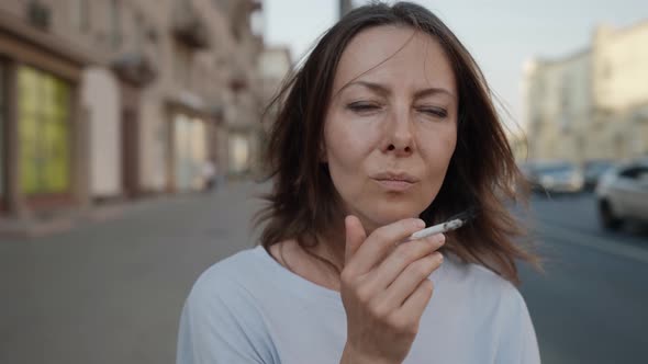 Portrait of a Brunette on a City Street Against the Background of Passing Cars is Out of Focus alt
