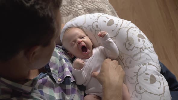Grandfather Tickling Newborn Baby Girl alt