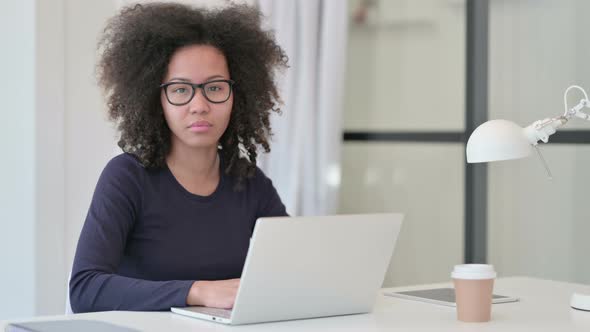 African Woman with Laptop Looking at Camera alt