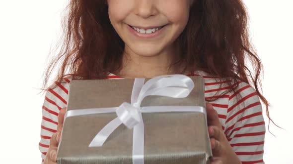 A Happy Girl Face with a New Year Gift in Hands