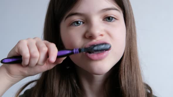 Little Beautiful Girl Brushes Her Teeth with a Toothbrush and Toothpaste