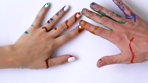 Creative Concept  Man and Woman Make Prints of Their Painted Hands on a White Background alt