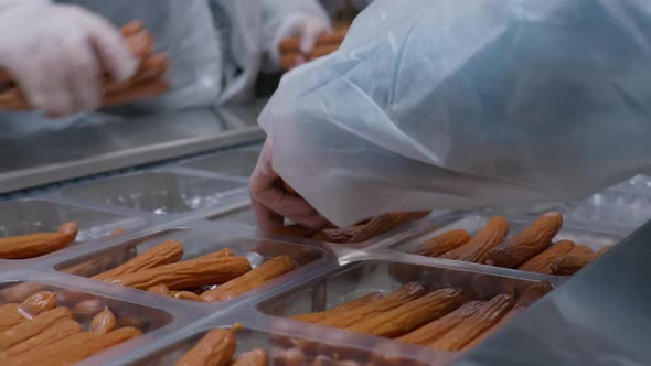 Workers of the Meat Processing Factory Place Readymade Sausages in Plastic Packages alt