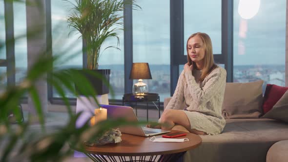 Attractive Woman Sitting on Couch and Typing on Laptop alt