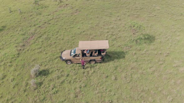 Man gets into 4 wheel drive vehicle after walking safari vacation in Laikipia, Kenya. Aerial drone v alt