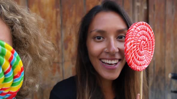 Two Funny Women Dancing on Street With Sweet Lollipop Candies. Closeup alt