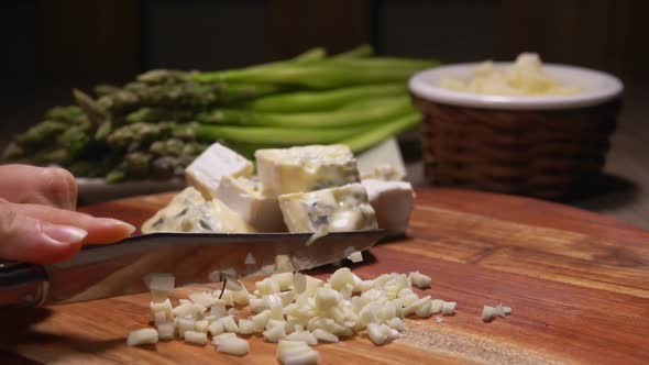 Hands Chop Garlic Into Small Cubes on a Board alt