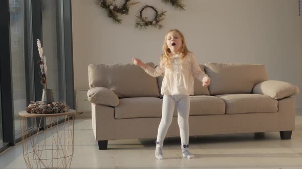 Little girl dancing in living room at home.