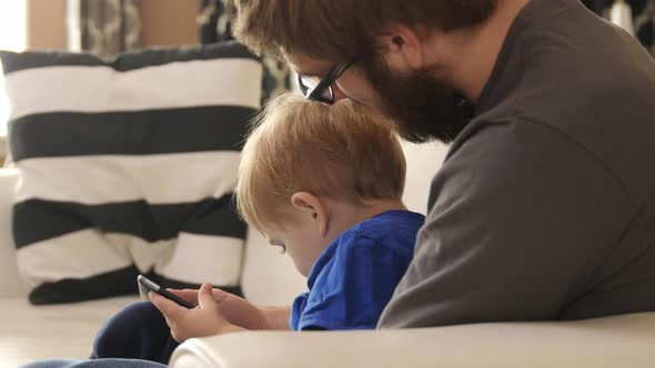 Father and Son using smart phone together