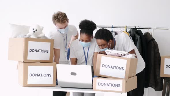 Volunteers Wearing Masks Sorting Clothes Donations During Pandemic alt