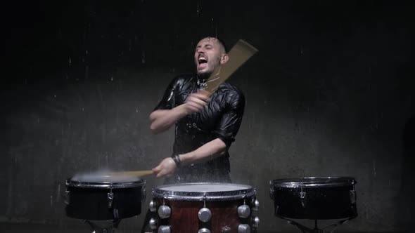 Drummer Playing Drums with Water in a Dark Studio alt