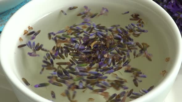 Tea from fresh lavender flowers on a vintage wooden background. Tea is brewed in hot water in a cup. alt