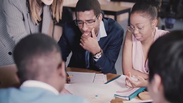 African American Colleagues Sit Together By the Table, Work on Architecture Documents at Multiethnic alt