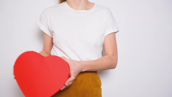 Woman Dancing and Hugging a Big Red Box in Shape of a Heart