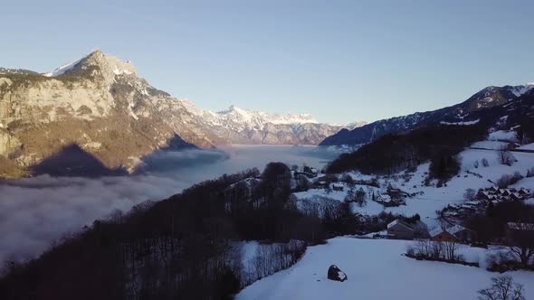 Flying straight over a small village in Switzerland. The left is covered with fog. alt