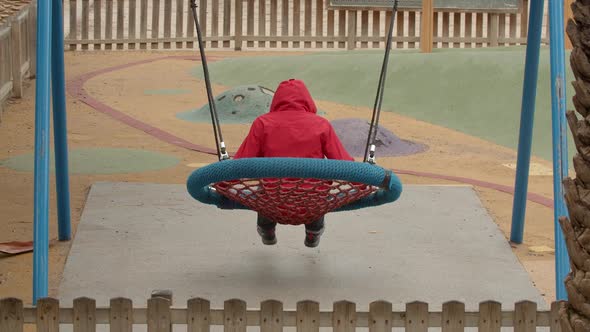 Boy Swinging In A Park
