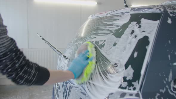 Car washing and detailing. Professional worker is washing a car. Slow mo. Transport disinfection. alt