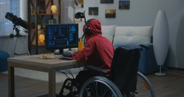 Disabled Boy Hacking on His Computer alt