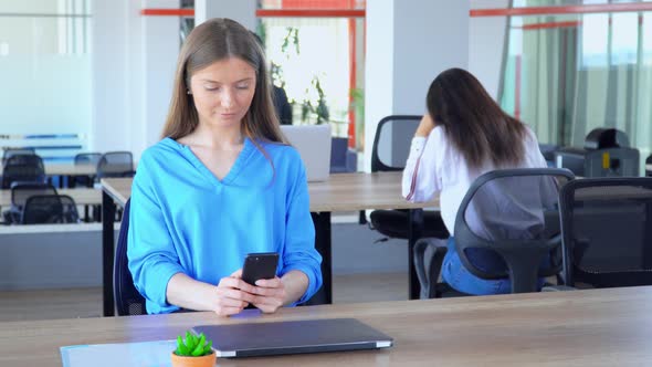 Caucasian Manager Using Smartphone at Workplace alt