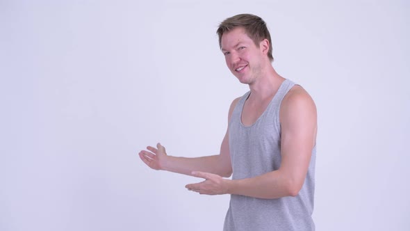 Happy Young Scandinavian Man Showing Something To the Back alt