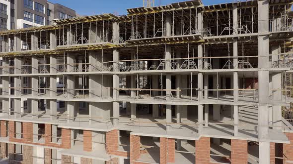 Building crane and monolituc building under construction. Construction site alt