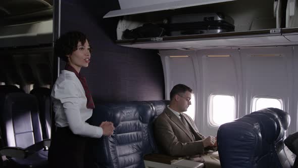 Flight attendant helps passengers board airplane