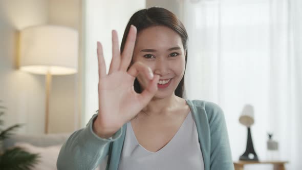 Portrait of Beautiful Asian Woman Saying Ok or Perfect by Finger Sign