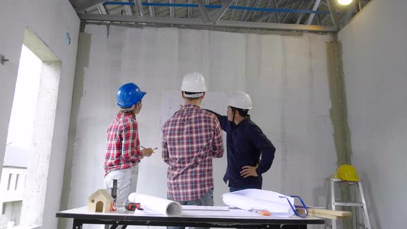 Engineers team discussing together with a blueprint on the drawing table in the village project