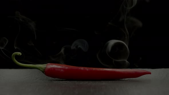 Cayenne chili pepper with smoke effect on black background