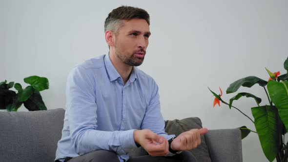 Angry Adult Man with Mental Health Talking to Doctor Psychotherapist in Clinic alt