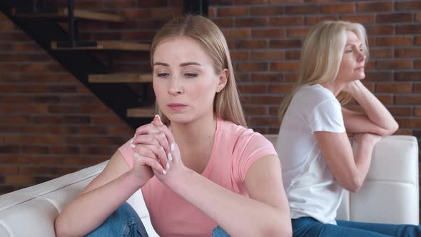 Frustrated Young Adult Woman and Mature Mother Turn Back on Sofa After Conflict alt