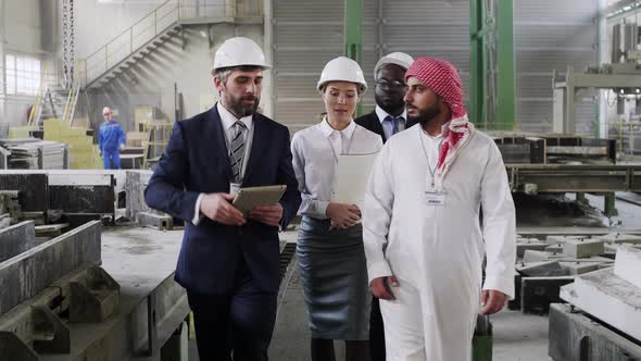 Caucasian factory managers welcoming international guests