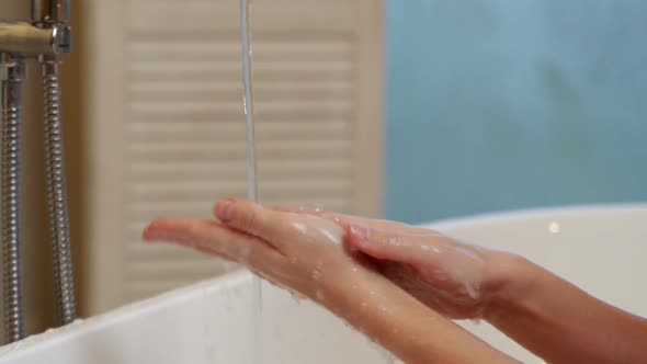 Closeup of a Woman Washing Her Hands in the Bathroom to Prevent the Covid19 Virus Infection alt