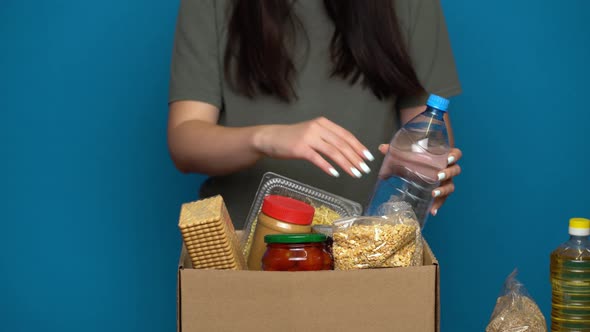Volunteer Putting Food in a Donation Box. Charity Concept alt