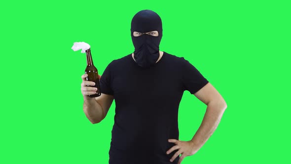 A man in a black mask holds in his hand a bottle with a prosperous mixture,