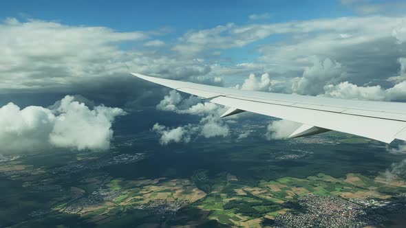 View on the Airplane wing from inside the plane while flying over Germany alt
