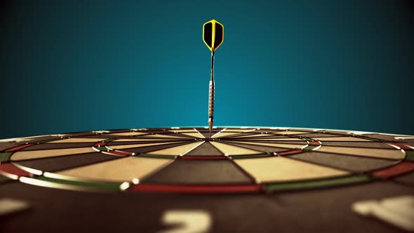 Darts arrow hitting in the bullseye of the dartboard hanging on the dark wall. alt