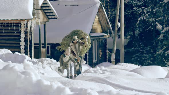 Family Carrying Christmas Tree in Snowy Countryside alt