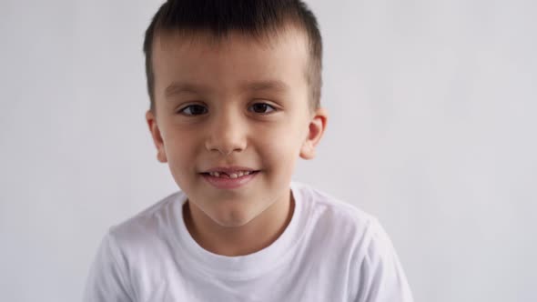 Boy Closeup Brown Eyes Look at the Camera Fooling Around Smiling Emotionally on White Background 4 alt