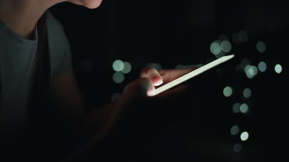 Female Hands Is Typing on a Smartphone at Night alt