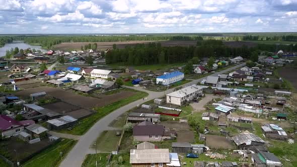 Village with Coloured House Roofs Against Green Forest alt
